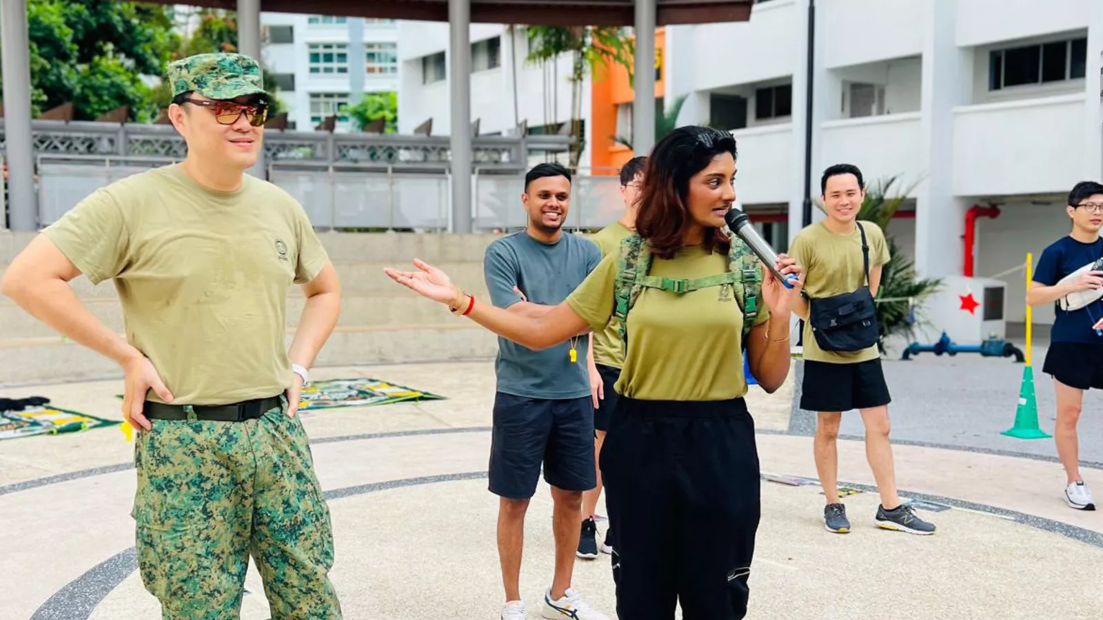 Parent Woon Qingyong, principal Sandhya Rubegan and others gather outdoors for a preschool event, dressed in army uniforms.