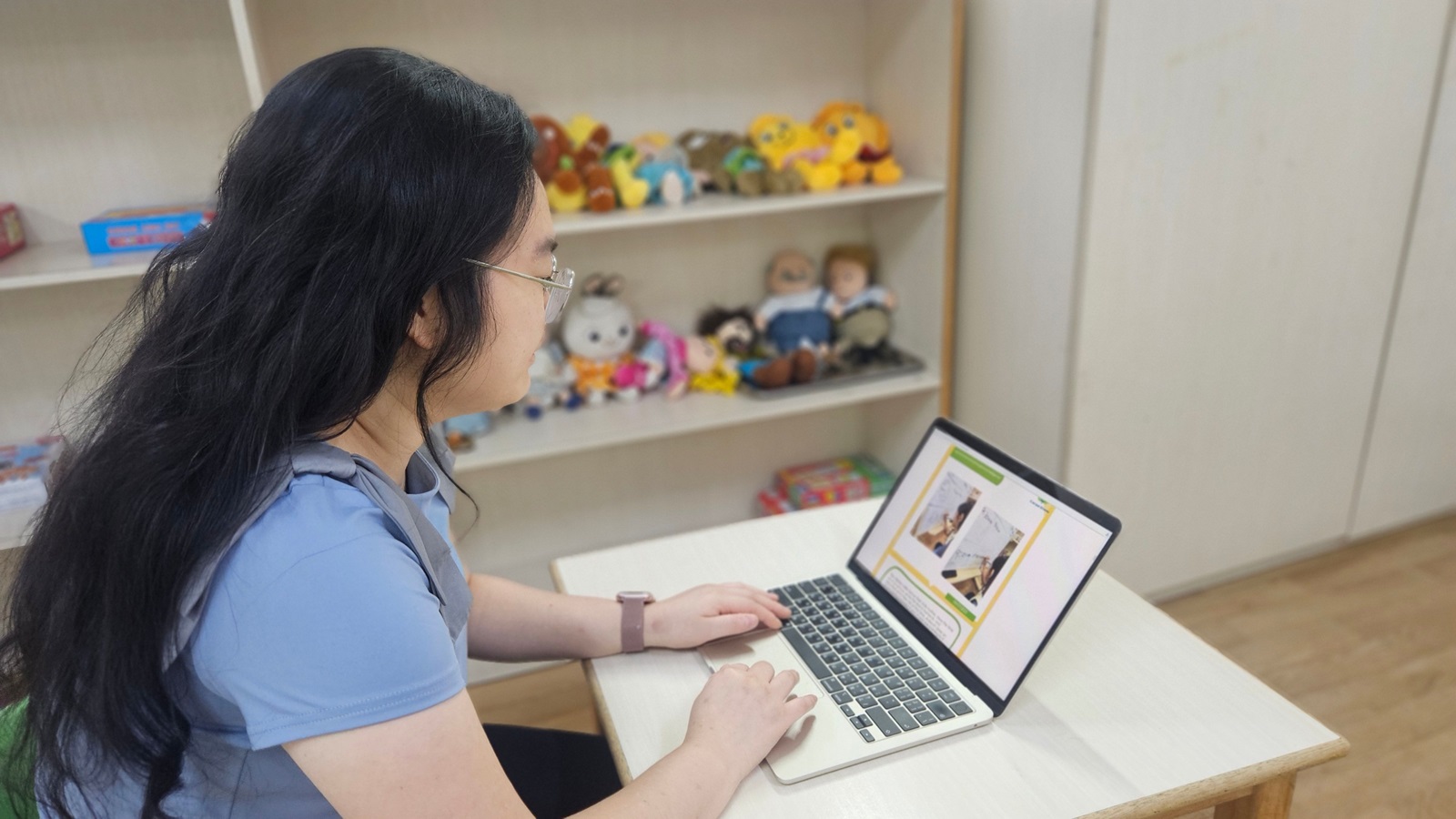 Educator working on a digital portfolio to share the child’s learning progress