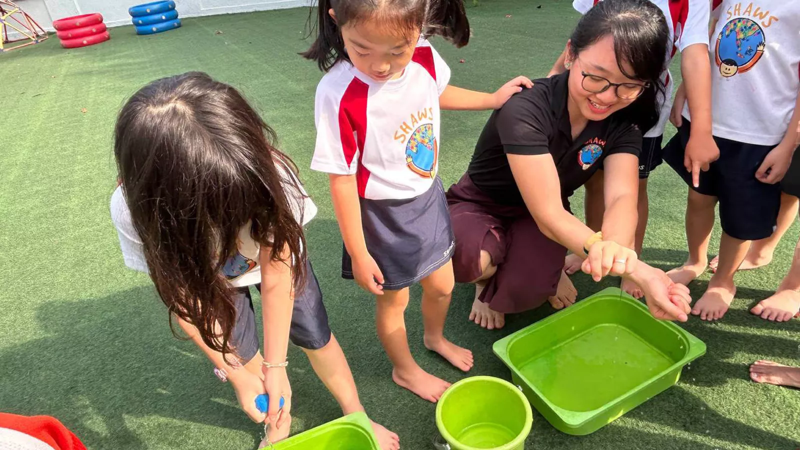 Children play with water in an outdoor activity, enjoying the sensory experience and hands-on exploration.