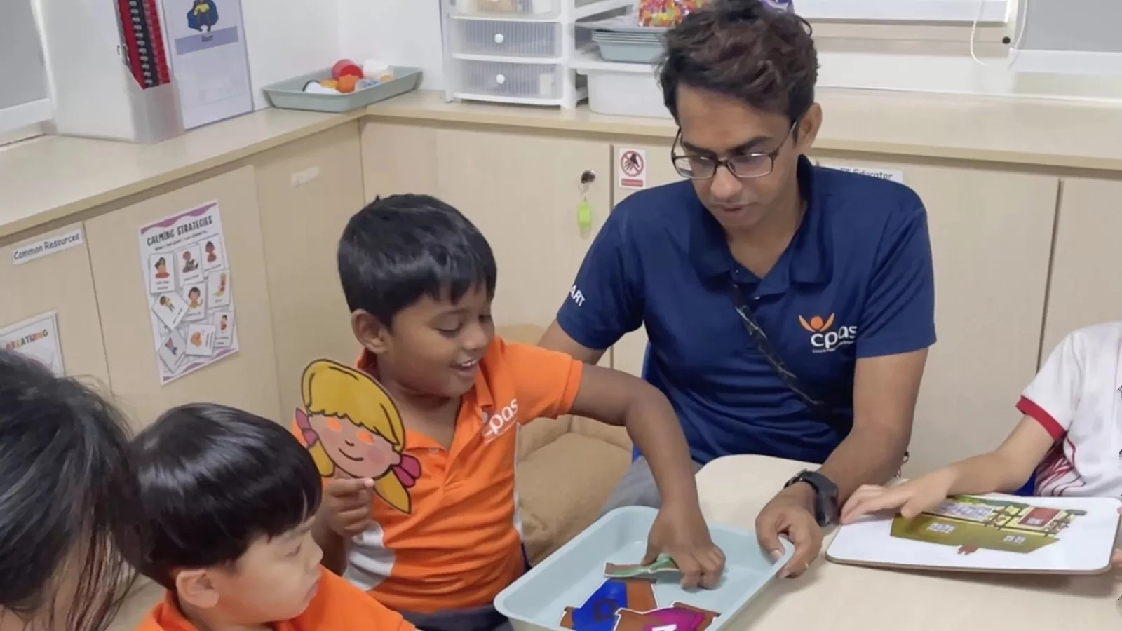 Children happily engage in a group storytelling session, where they use props to retell the story and build verbal skills.