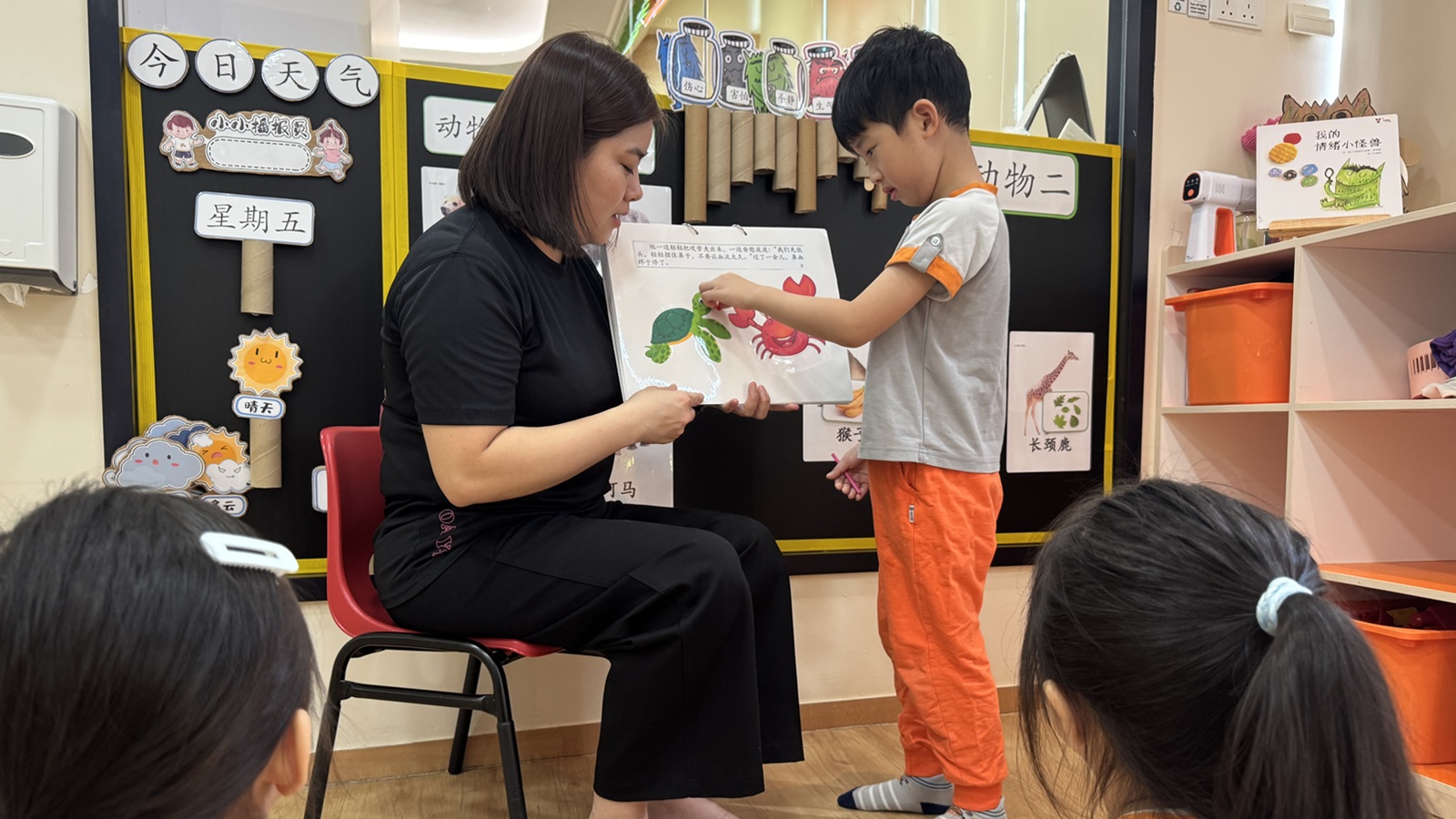 Educator using colourful visual aids to engage children in a storytelling session