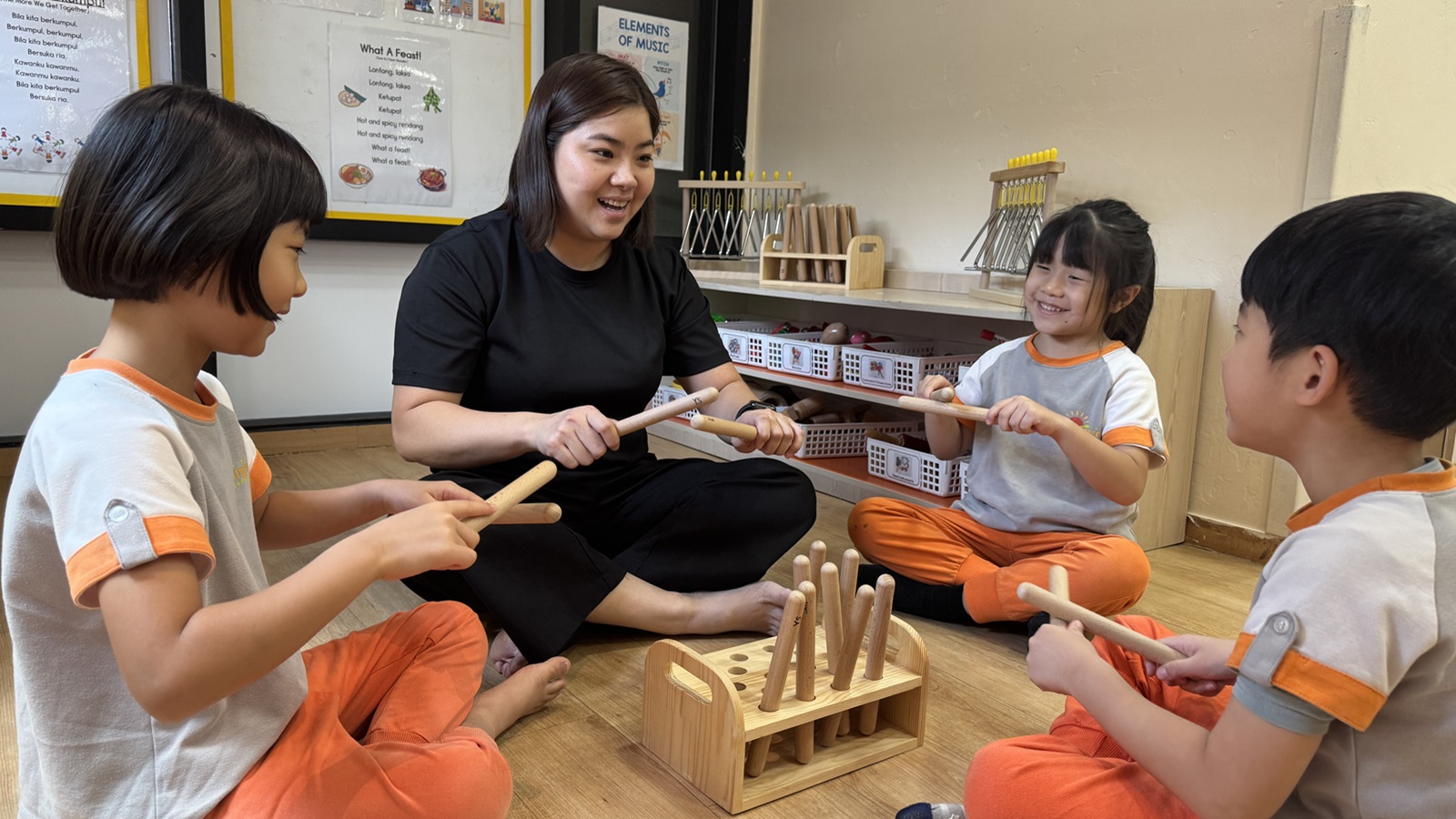 Educator engaged in a musical drumming activity with children