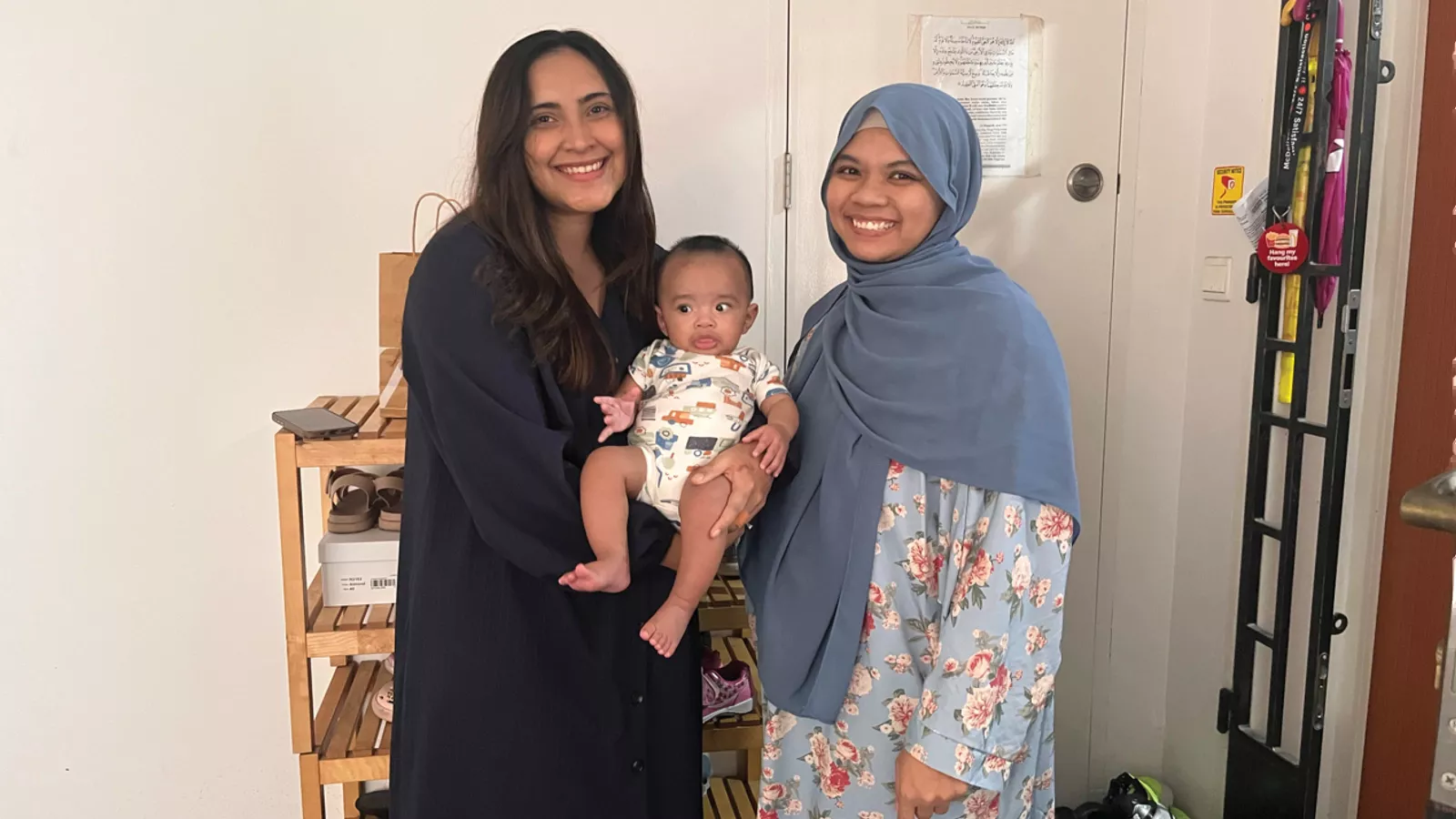 Ms Samira, her baby Niaz and childminder Ms Nadiyah happily smile for a group photo outside the latter’s home.