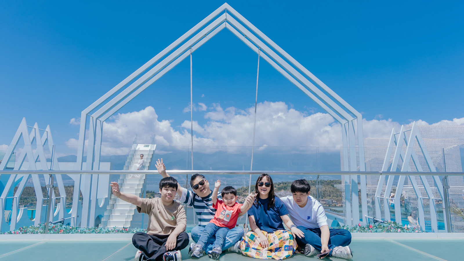 Parent Sabrina Ng and her family happily pose for a photo on a building rooftop, showcasing their strong family bond.