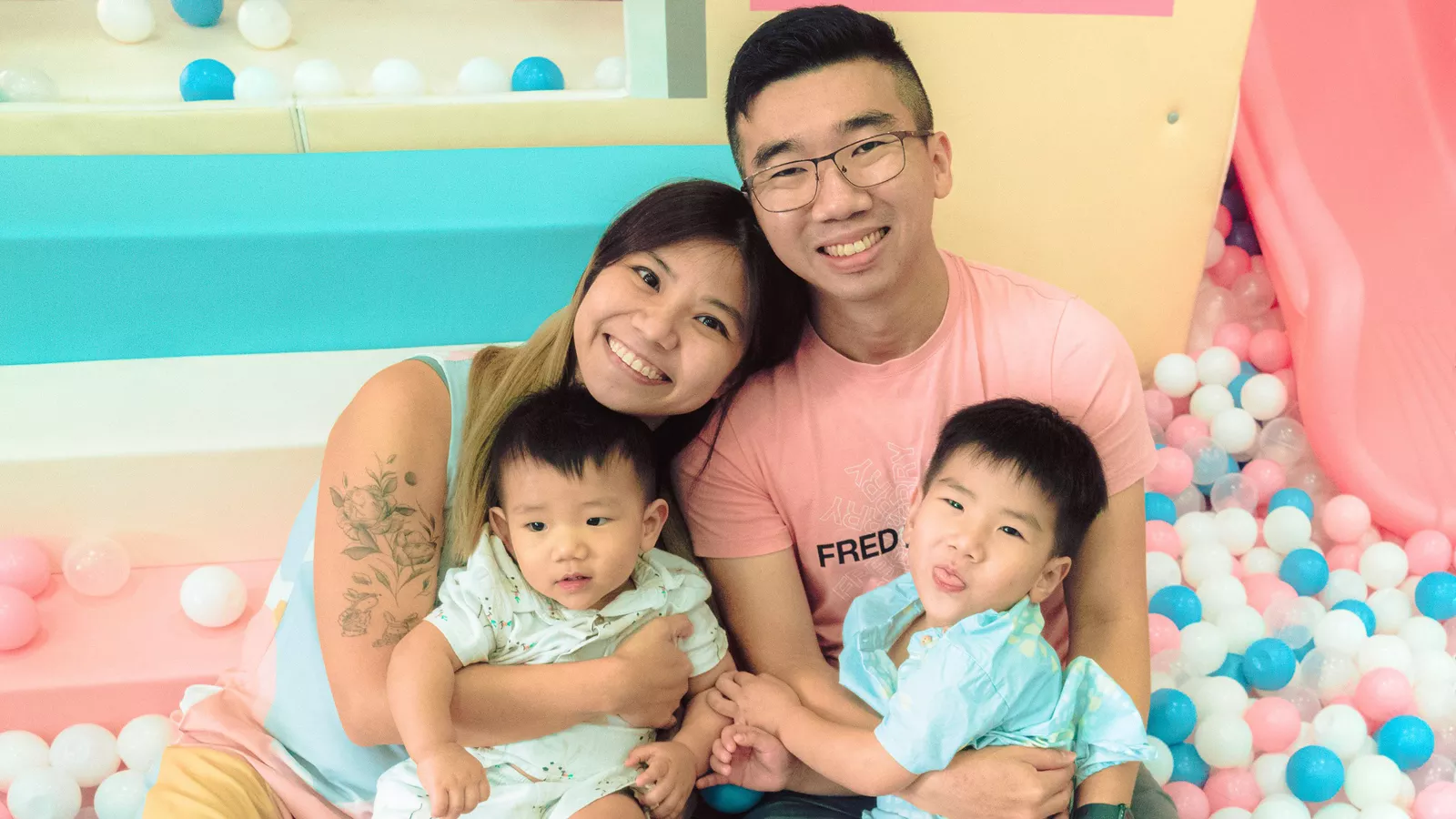 A family photo of Angela Ling, her husband and their two children in a ball pit, showcasing their closeness and warmth.