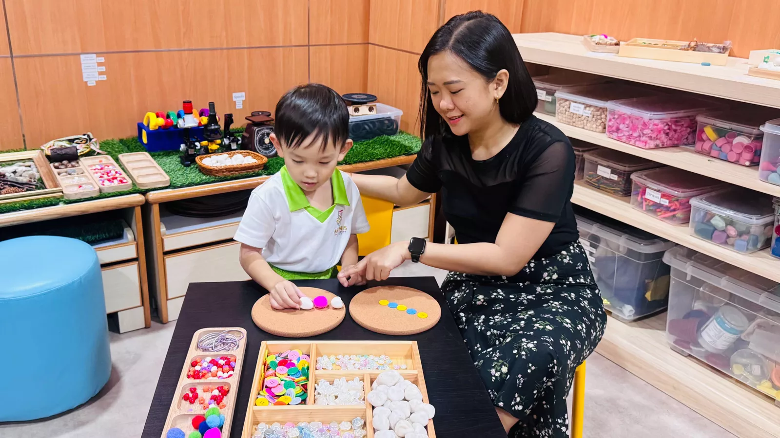 An educator teaches a child about patterns using a variety of different objects, such as buttons, beads and rocks.