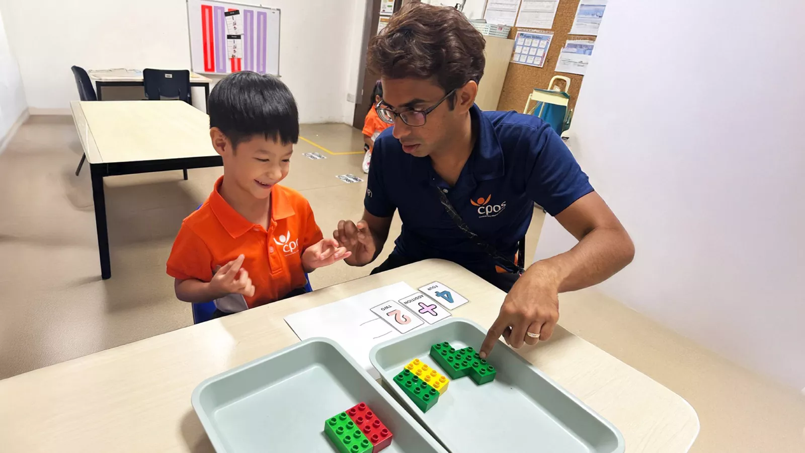Early intervention educator Kishure Kumar guides a child in a counting activity during a one-on-one session.