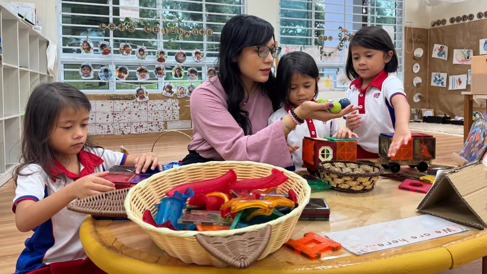 Principal Siti Nadiah joins children in a loose parts play activity, exemplifying the rewards of working in EC education.