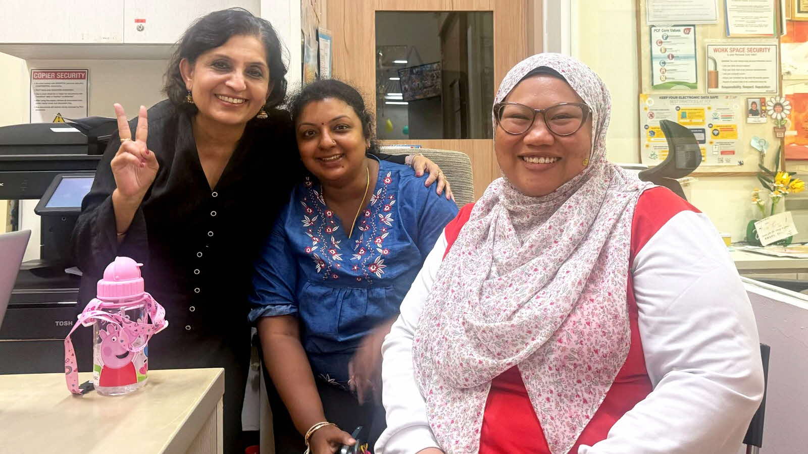 Parent Nithiyasri Subramaniam and two educators pose for a photo together, symbolising positive parent-preschool partnership.
