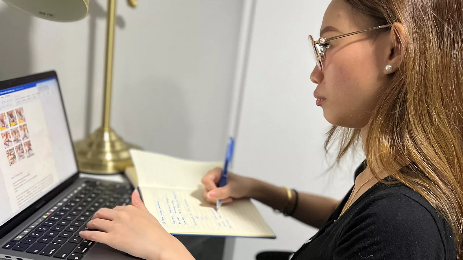Infant educator Zurhidah Matsidah sits at a desk with a laptop while taking notes, focused on professional training.