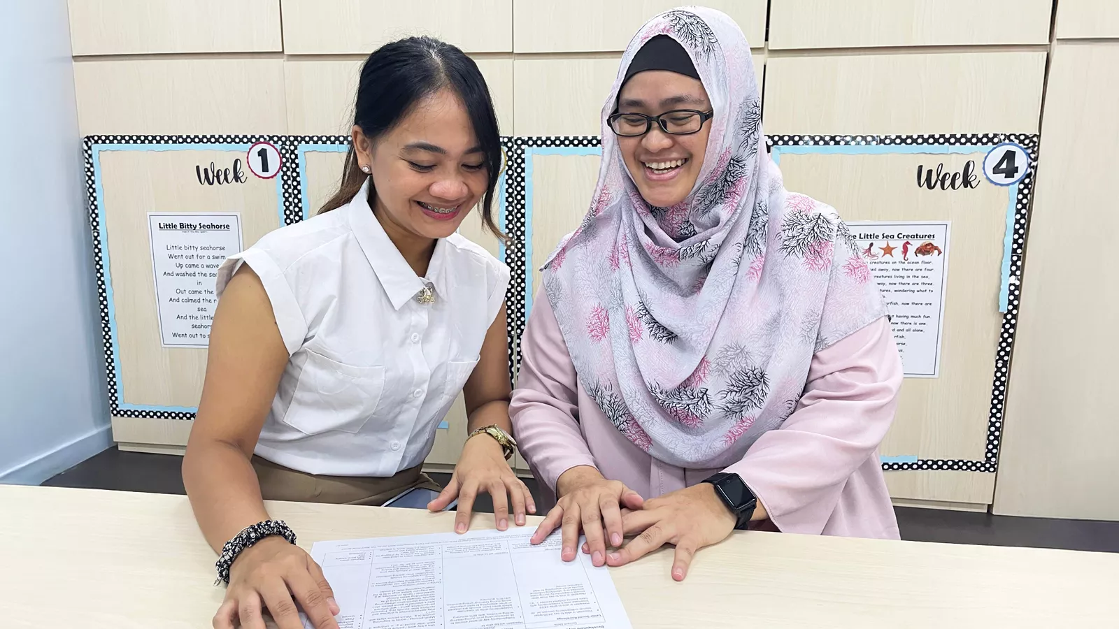 LSEd Nor Jannah reviews a document with an educator, empowering the educator to contribute to early intervention.