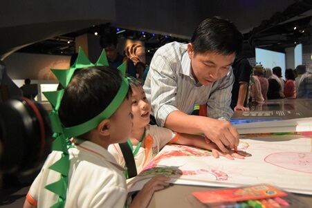 Minister Tan working on the Dinosaur artwork with the children!